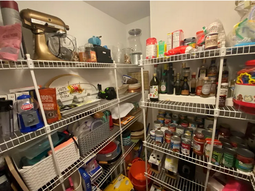 A pantry with many shelves of food and appliances.