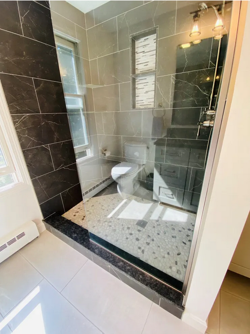 A bathroom with a toilet and tiled walls.