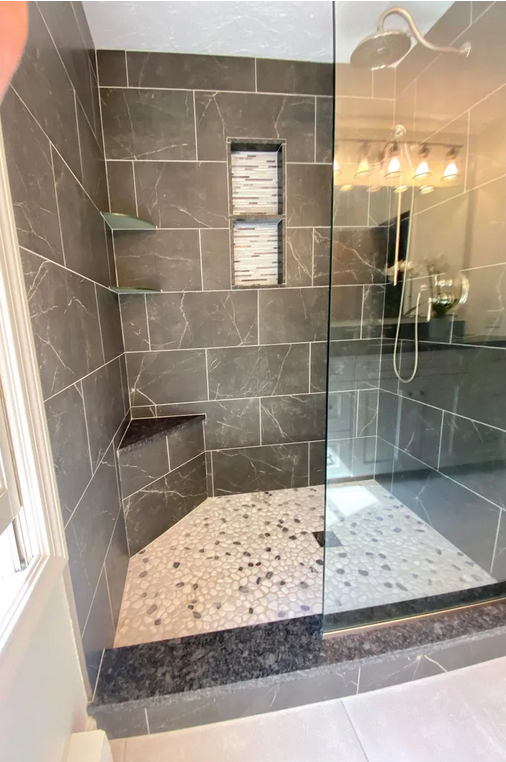 A bathroom with a shower and tiled floor