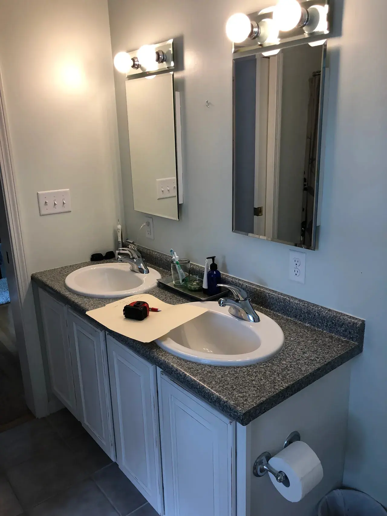 A bathroom with two sinks and a mirror.