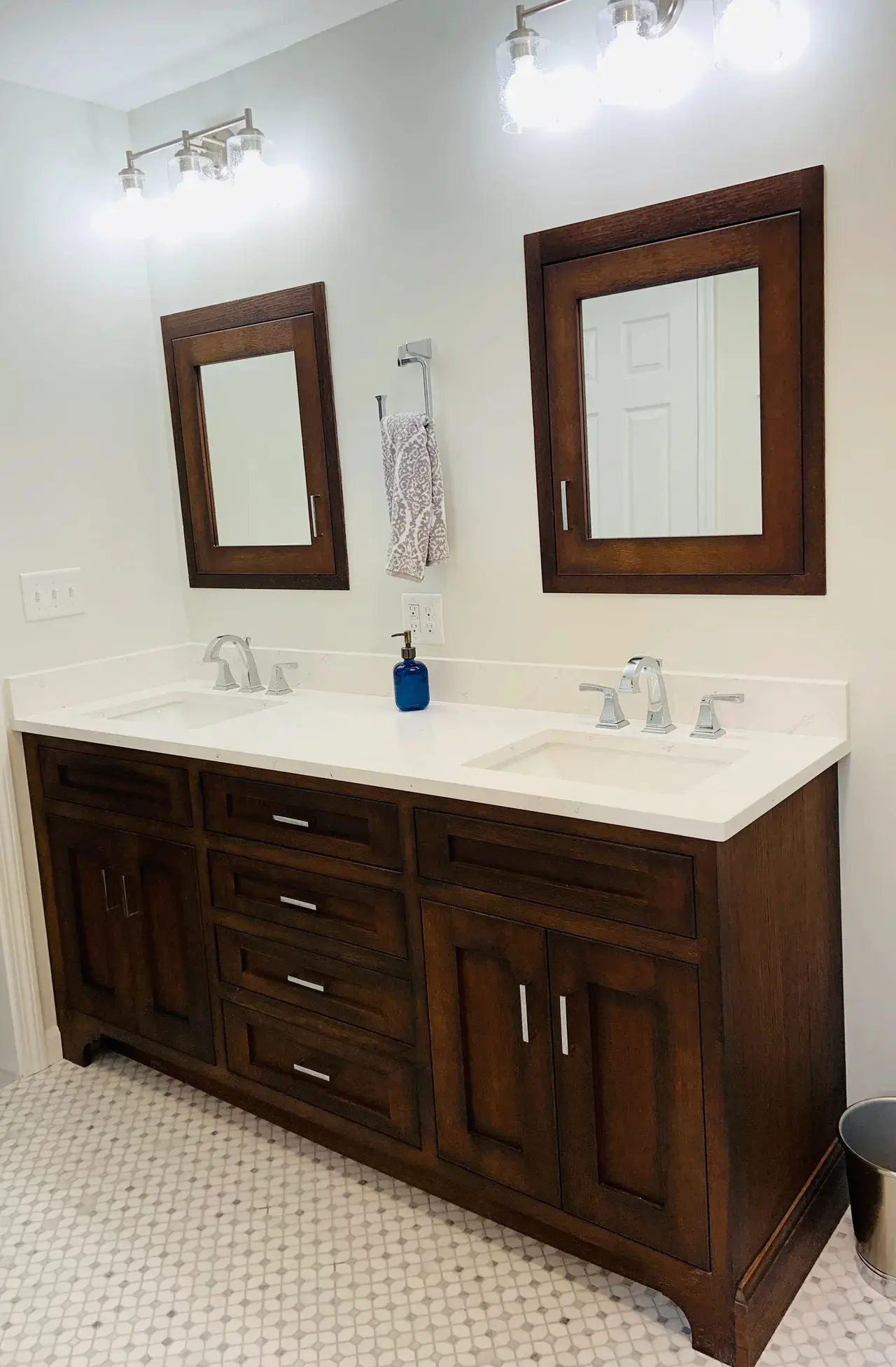 A bathroom with two mirrors and a double sink.