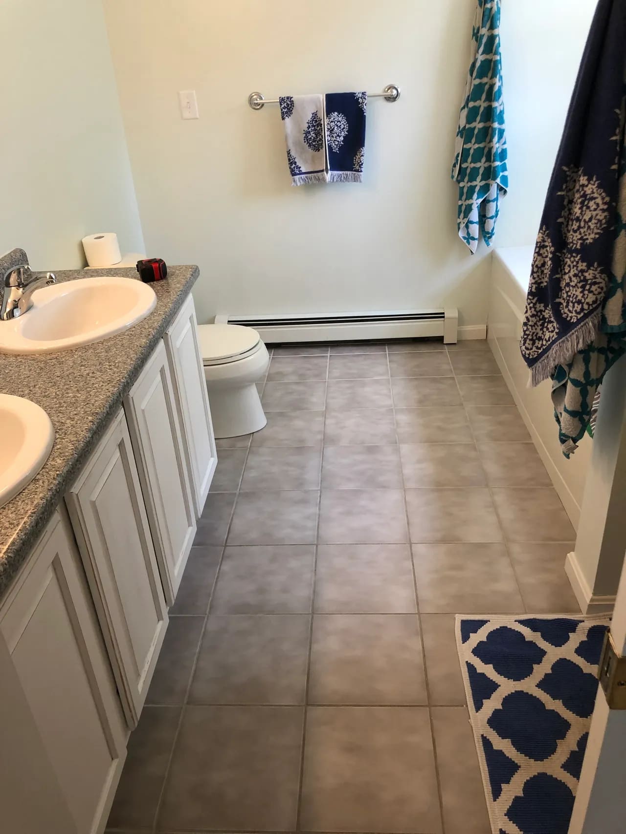 A bathroom with two sinks and tiled floors.