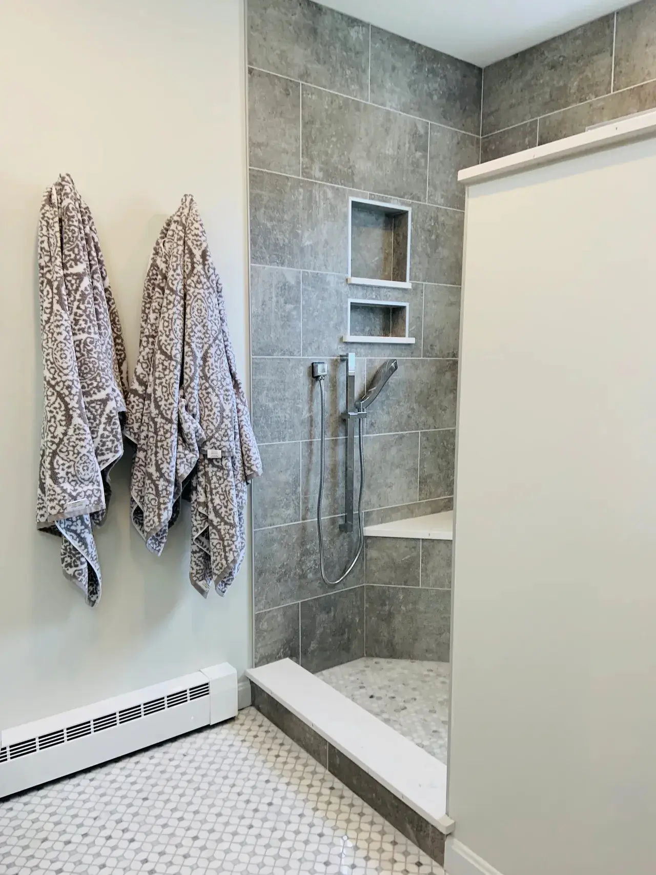 A bathroom with two towels hanging on the wall.