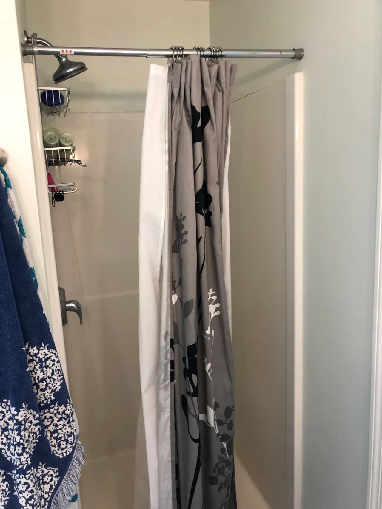 A shower curtain hanging in the corner of a bathroom.