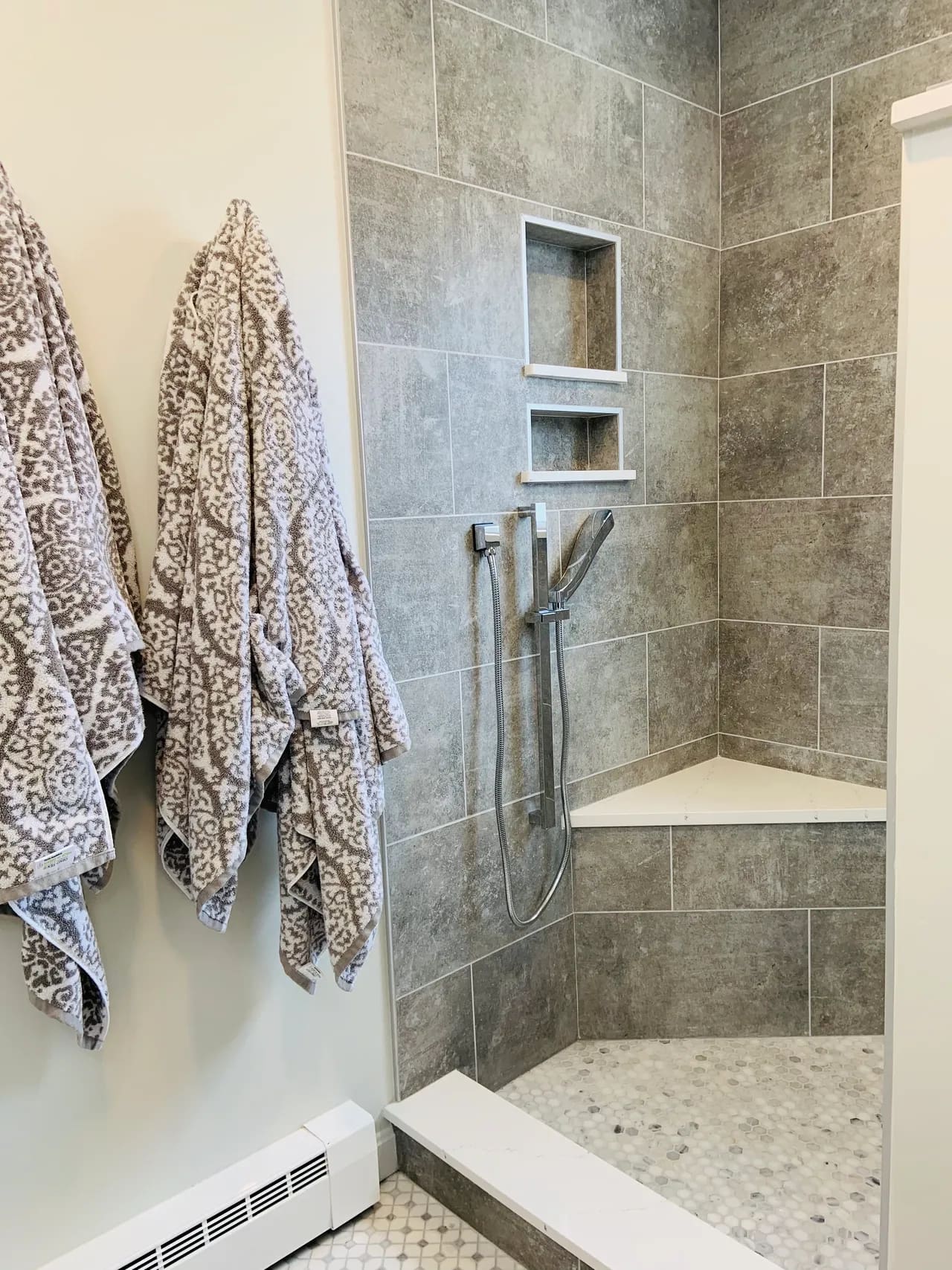 A bathroom with two towels hanging on the wall.