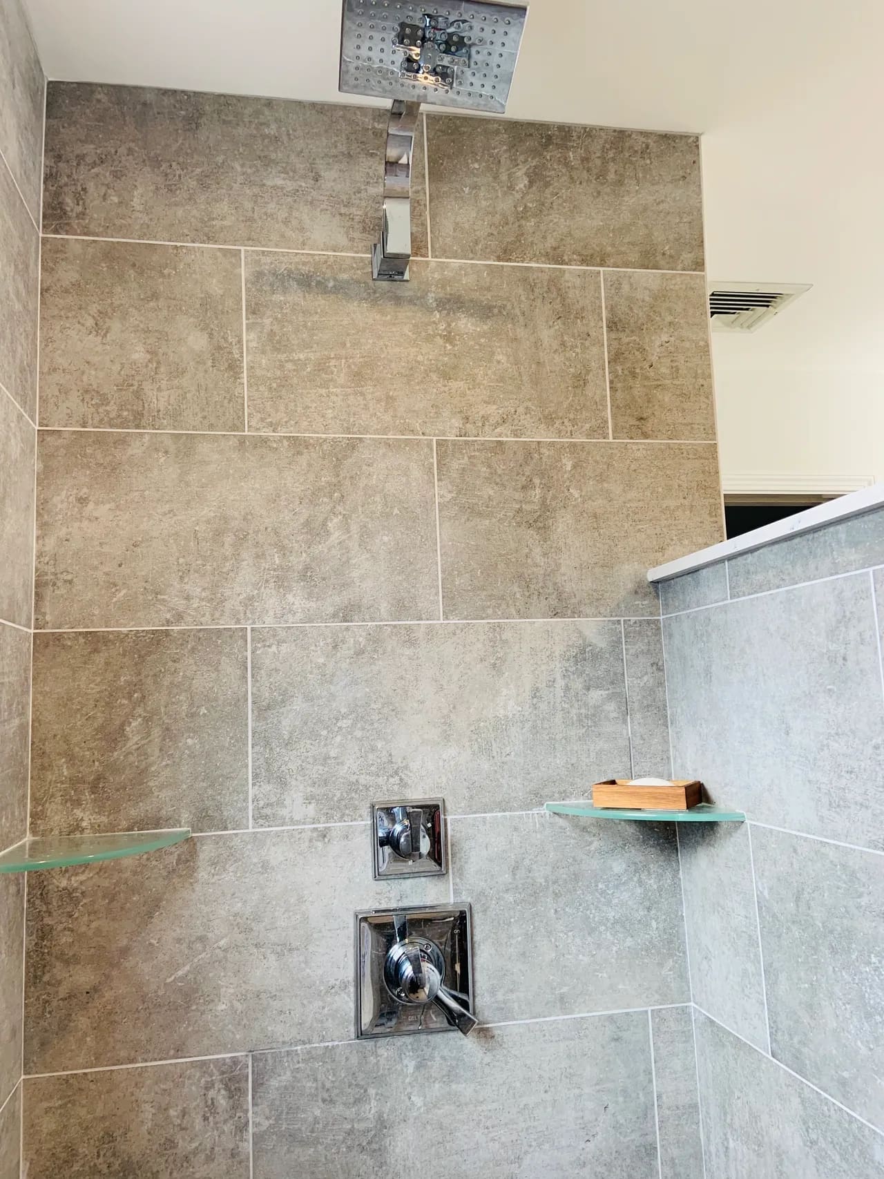 A bathroom with a shower and tiled walls.