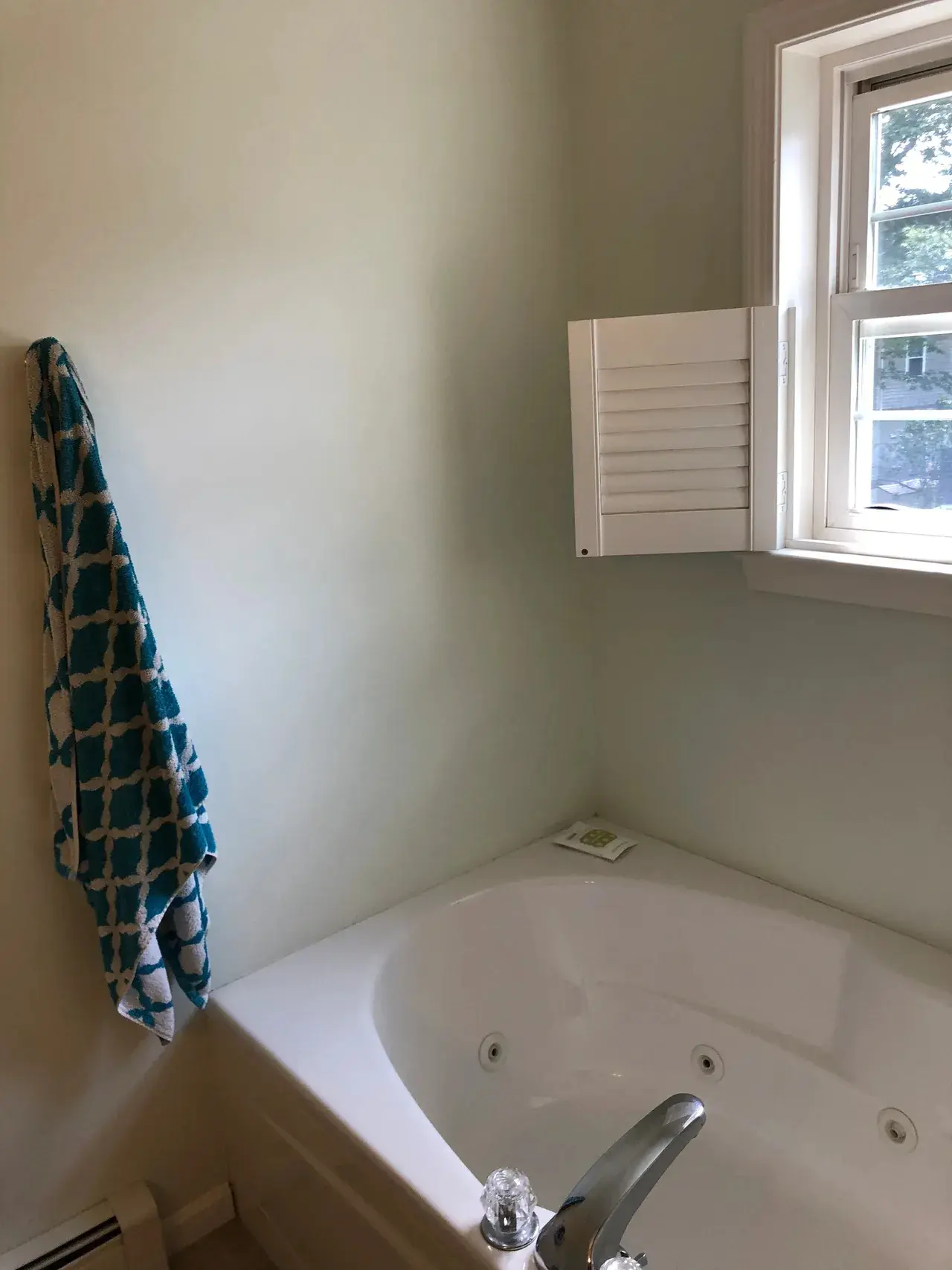 A bathroom with a tub and window in it