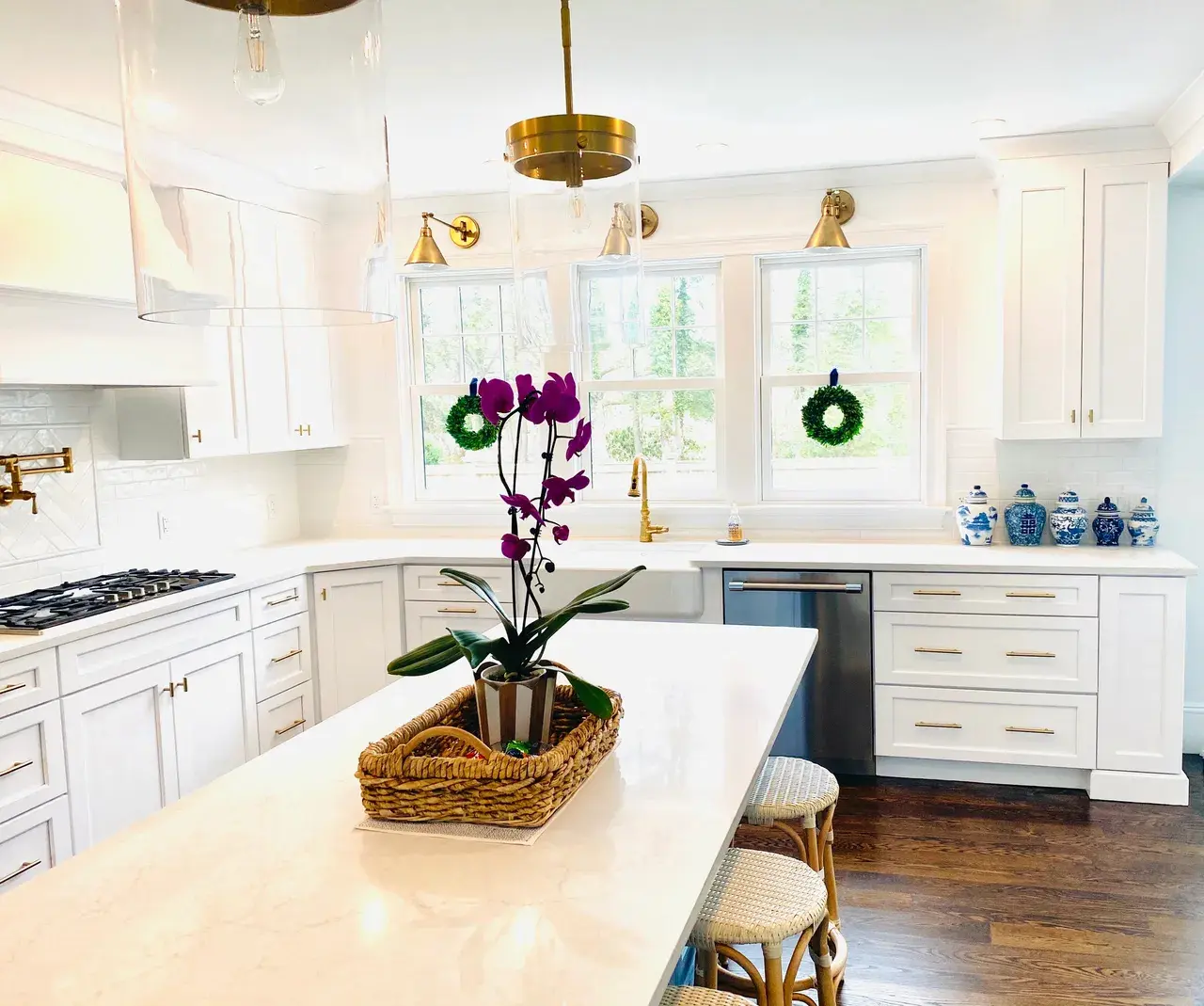 A kitchen with white cabinets and wooden floors.