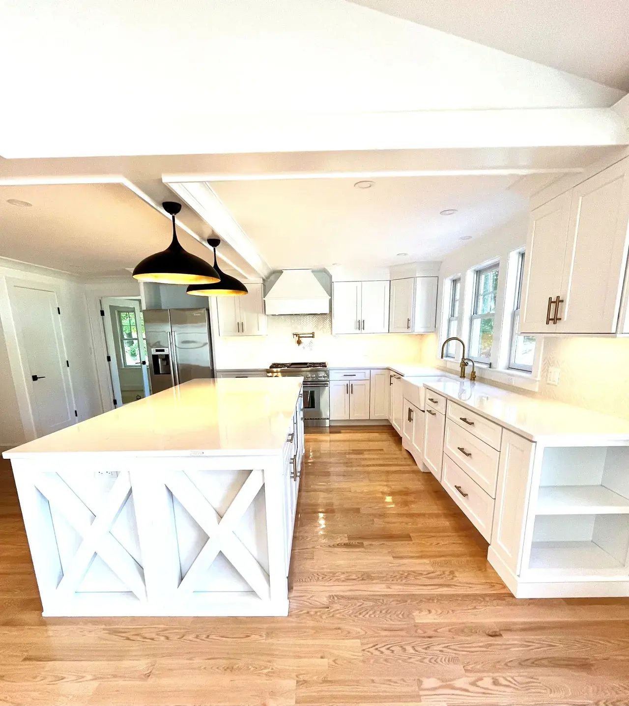 A large kitchen with white cabinets and wood floors.