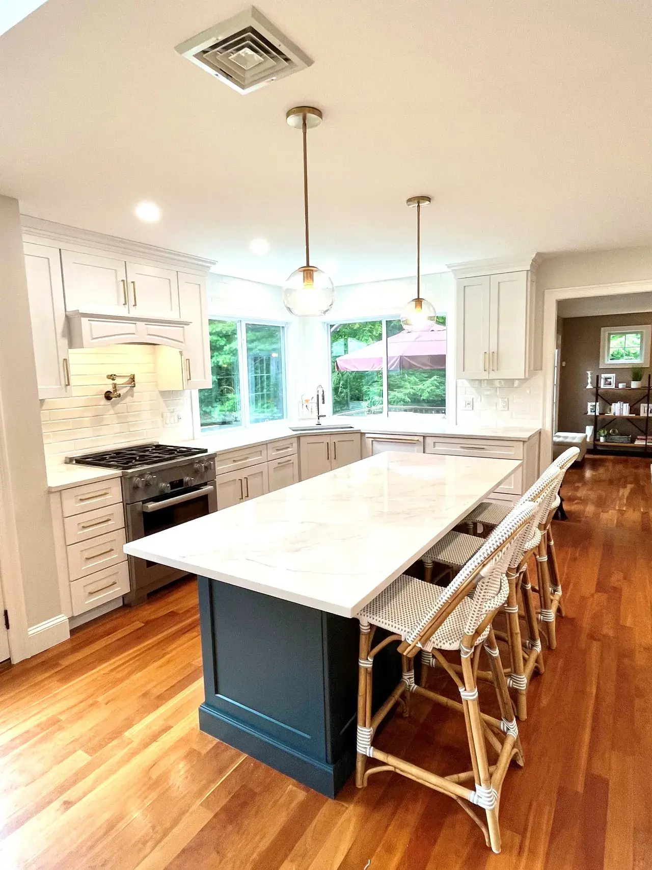 A kitchen with white cabinets and wooden floors.