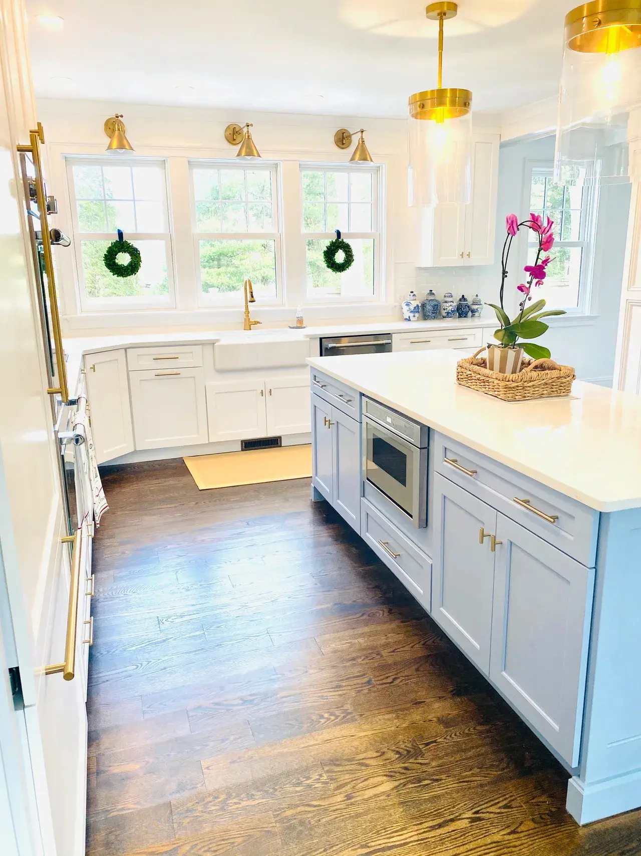 A kitchen with white cabinets and wood floors.