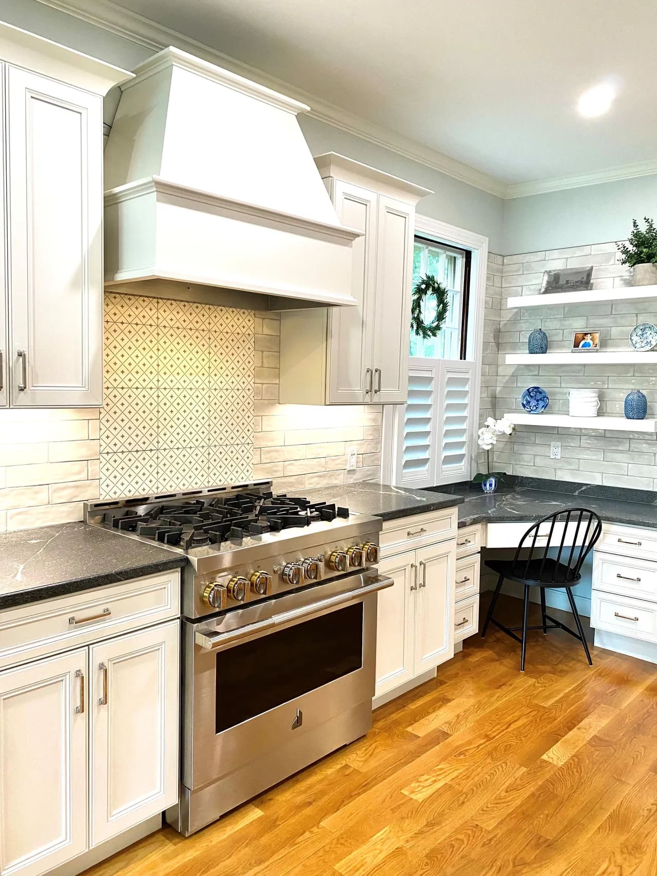 A kitchen with white cabinets and wooden floors.