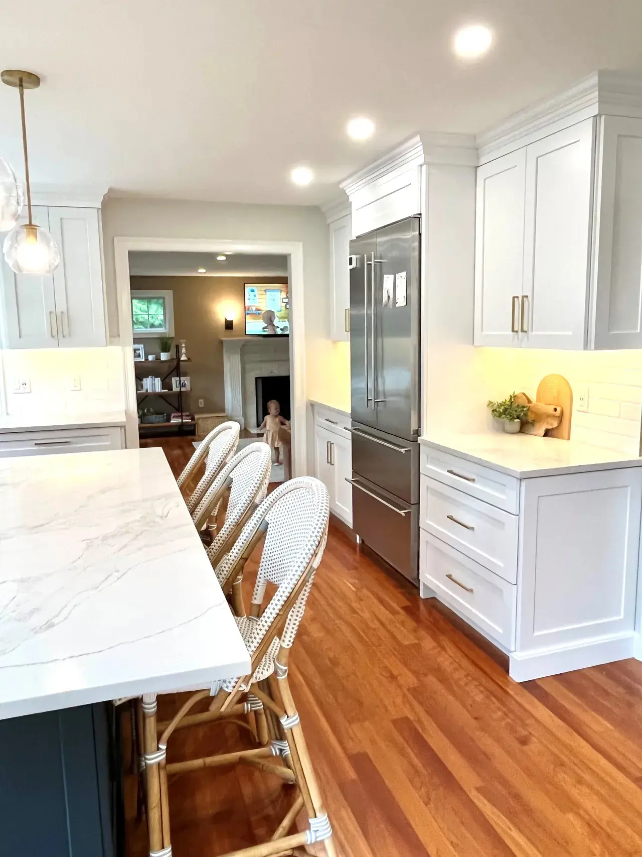 A kitchen with white cabinets and wooden floors.