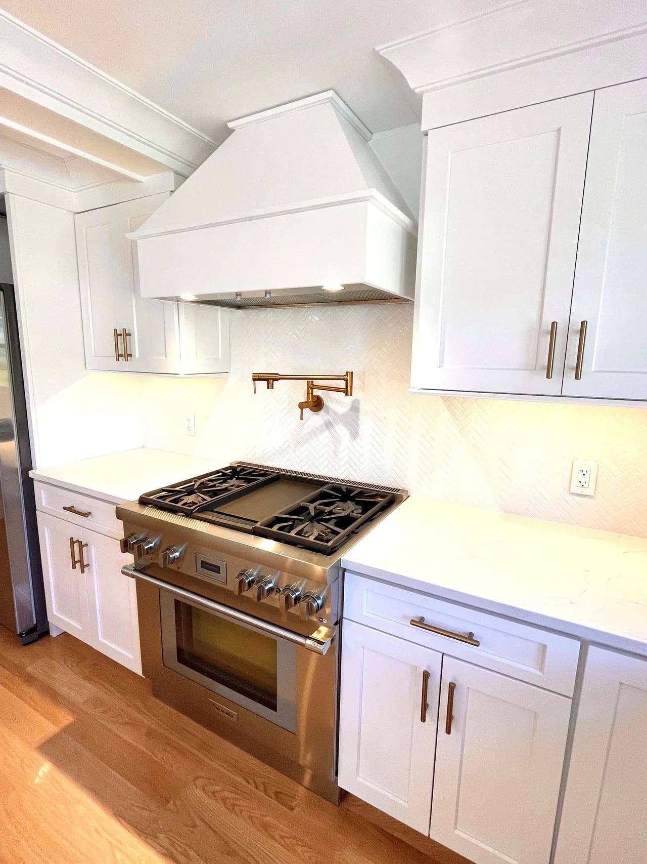 A kitchen with white cabinets and stainless steel appliances.