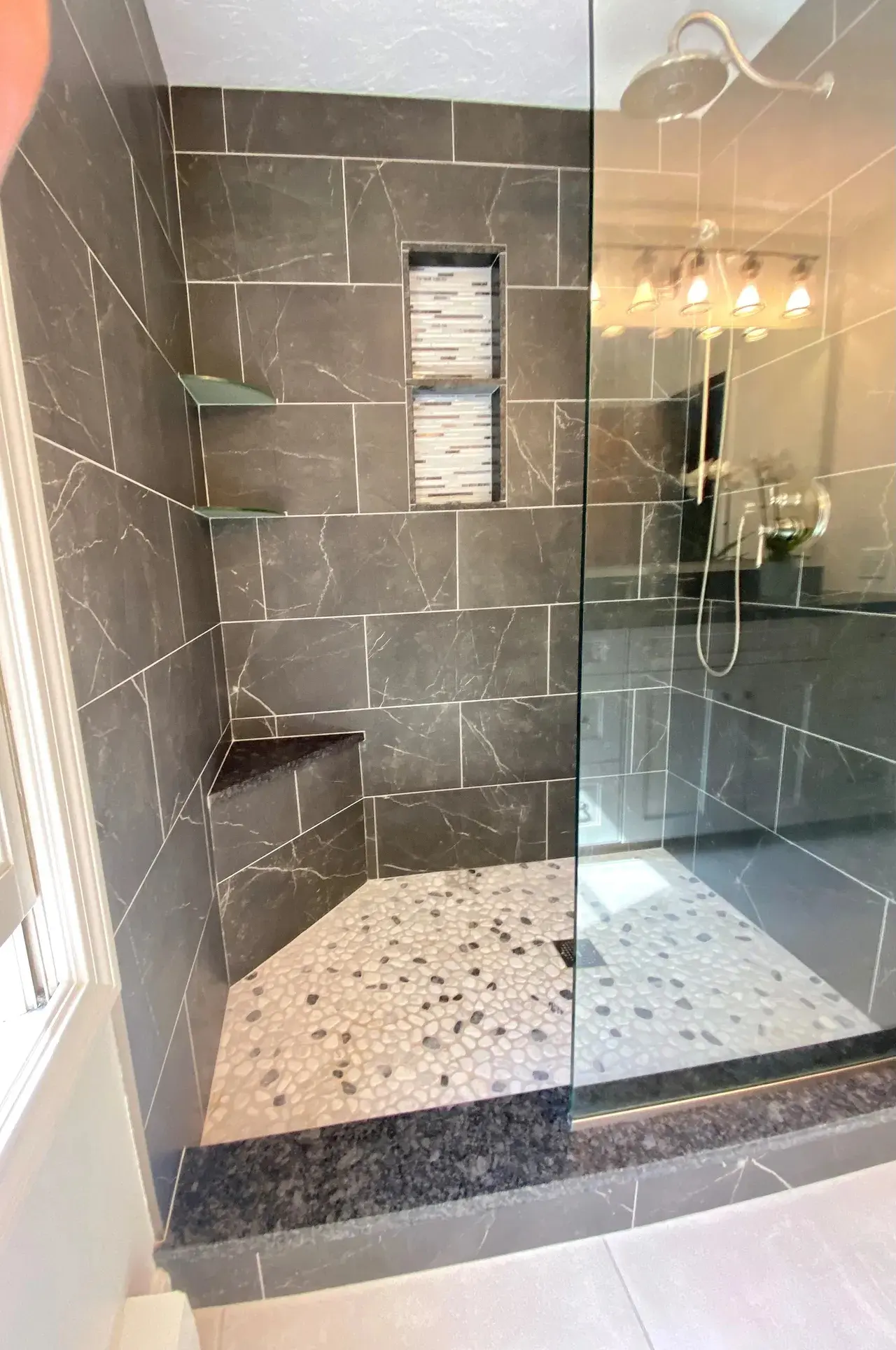 A bathroom with a walk in shower and tiled walls.