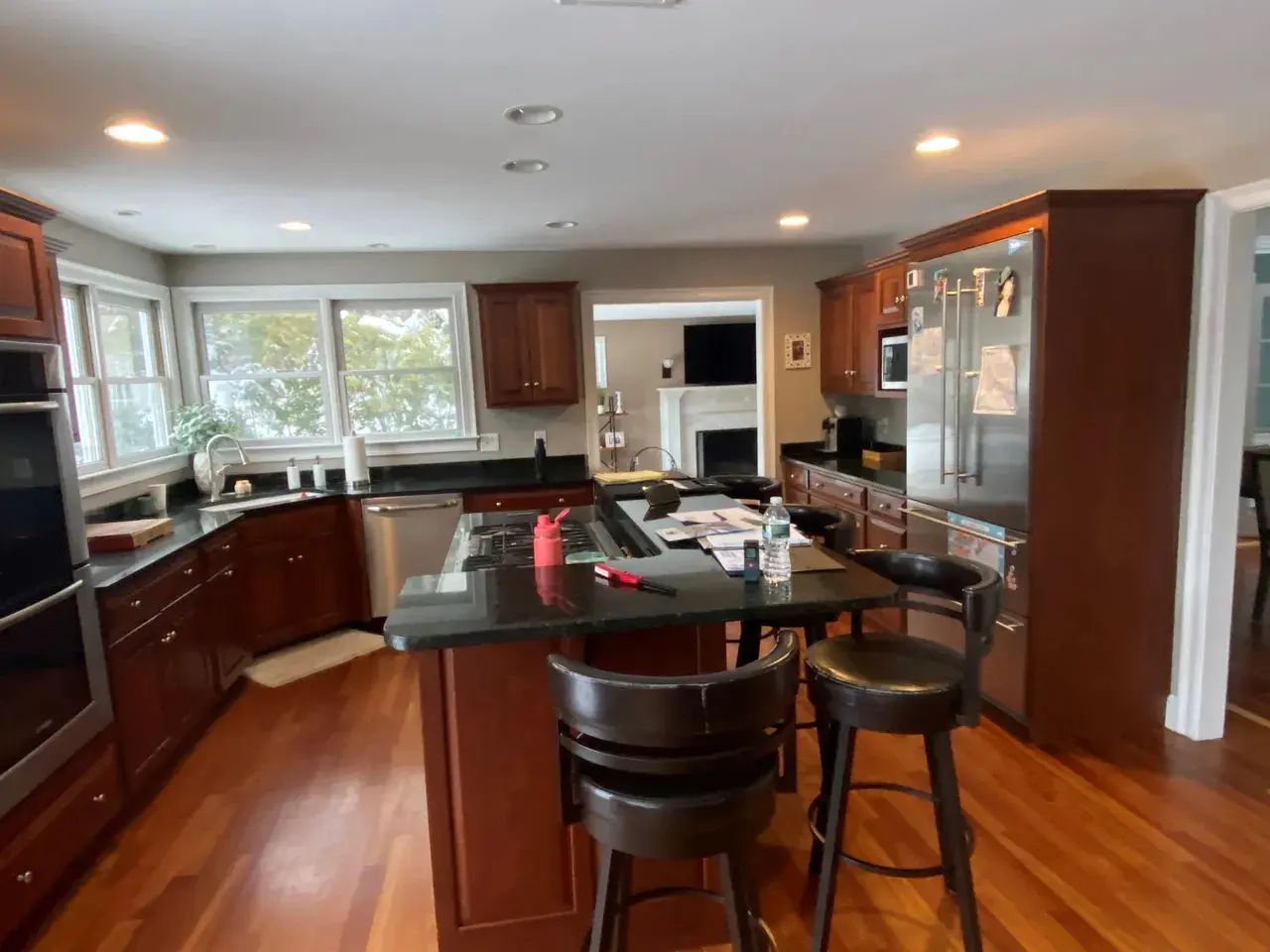 A kitchen with wooden floors and dark cabinets.