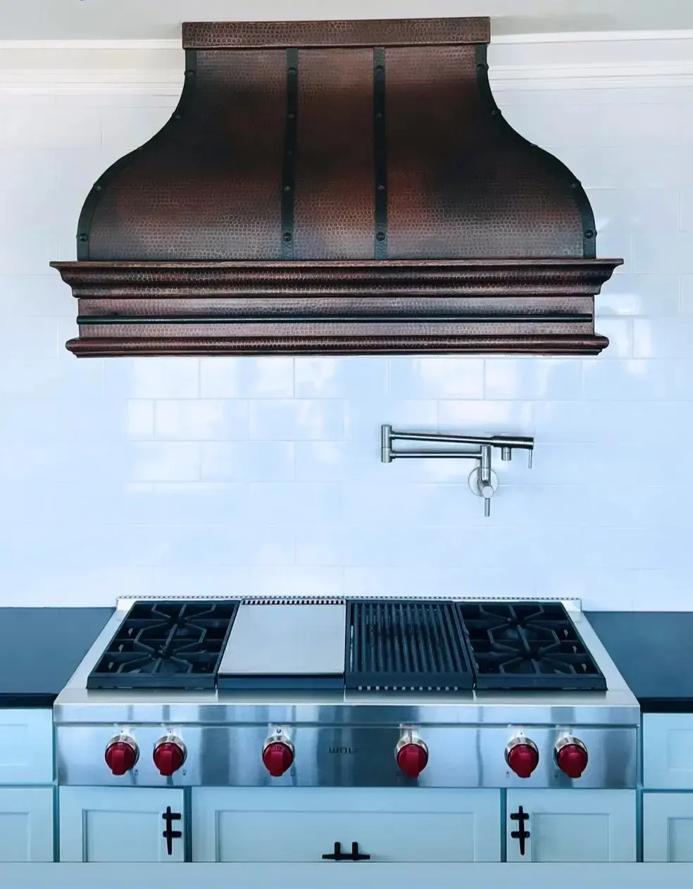 A stove top oven sitting under a wooden hood.