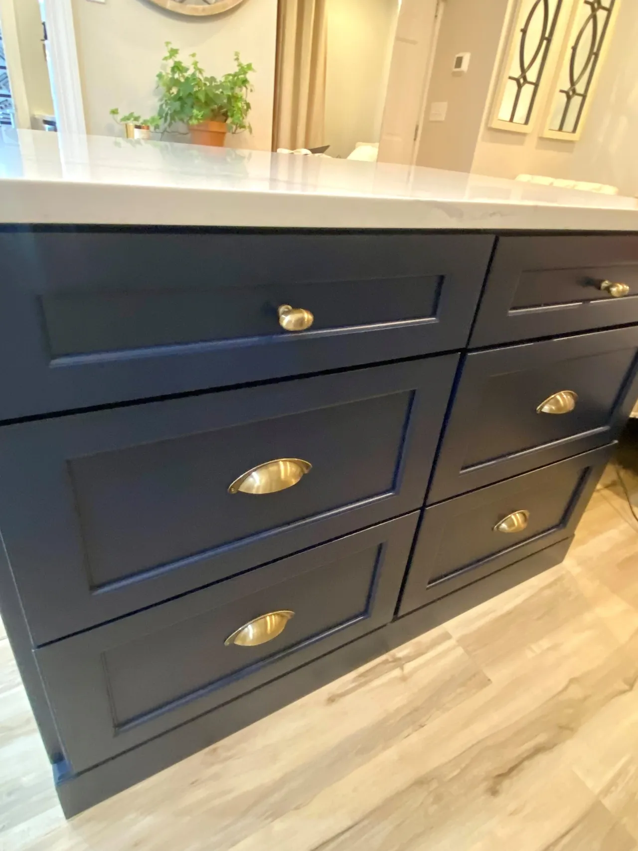 A kitchen with black cabinets and gold handles