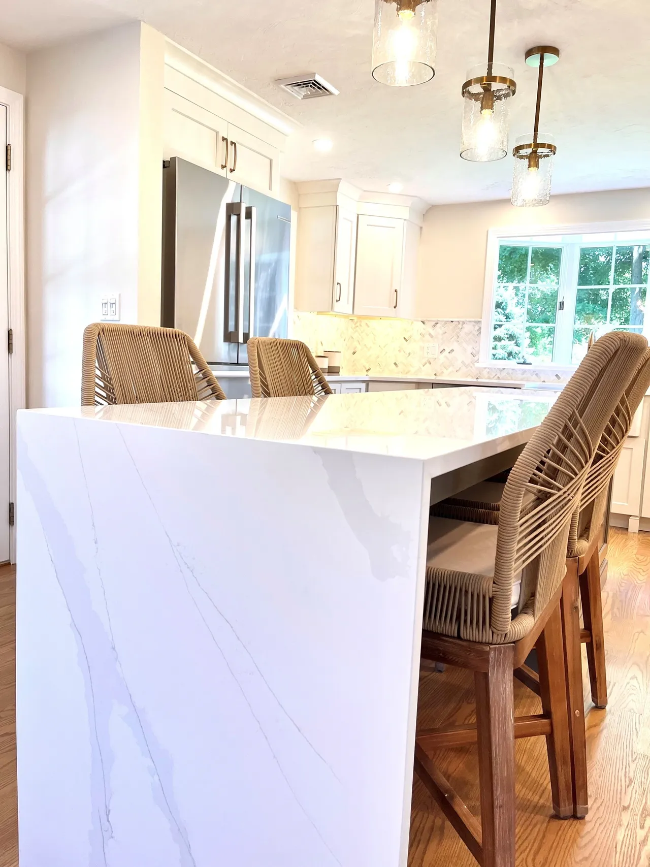 A kitchen with white cabinets and a large island.