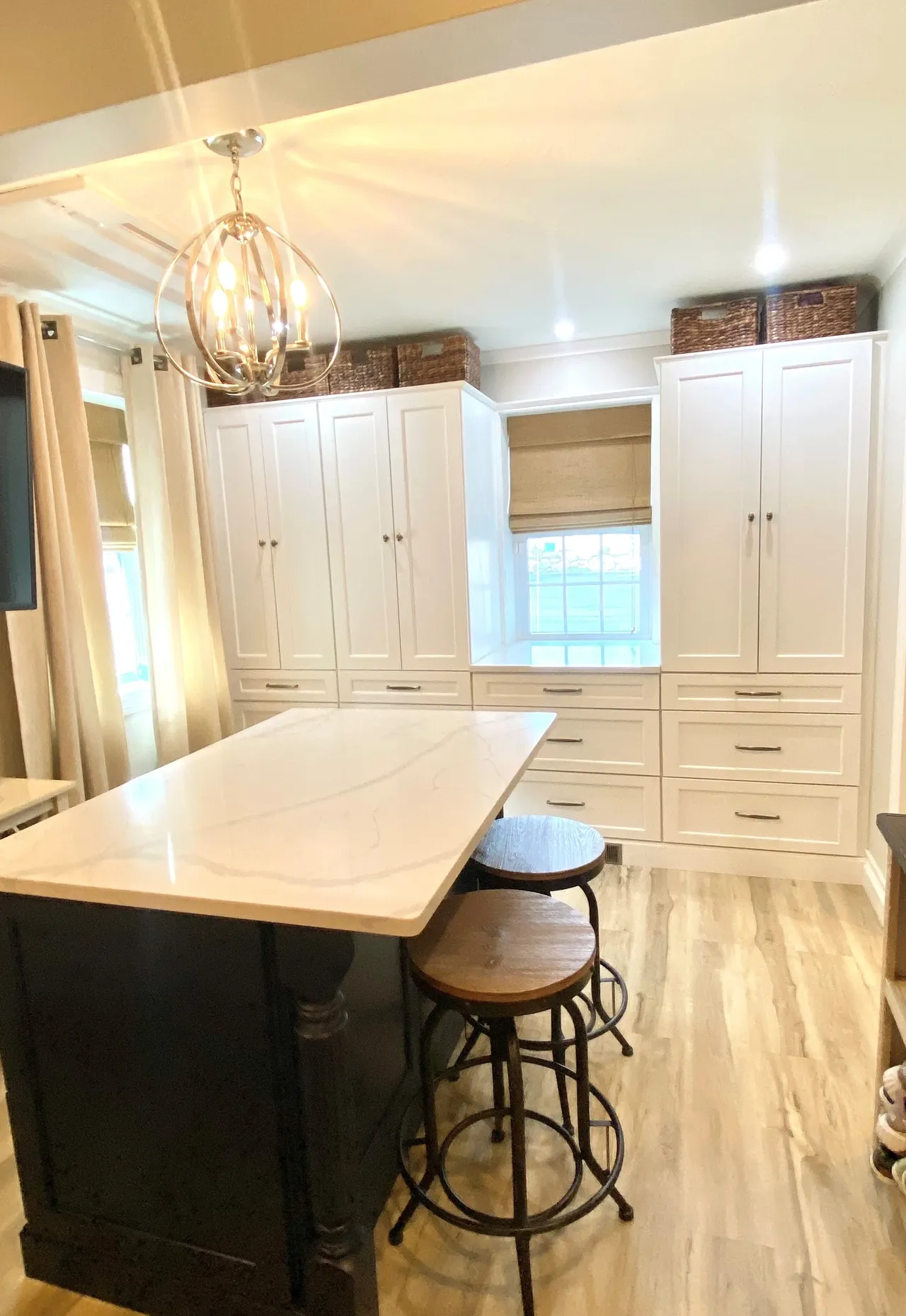 A kitchen with white cabinets and a large island.