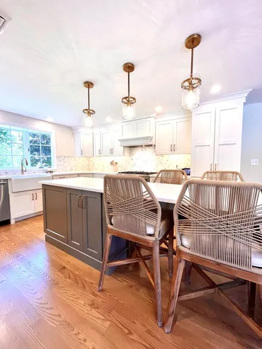 A kitchen with wooden floors and white cabinets.