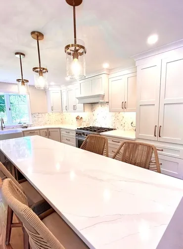 A kitchen with white cabinets and a large island.