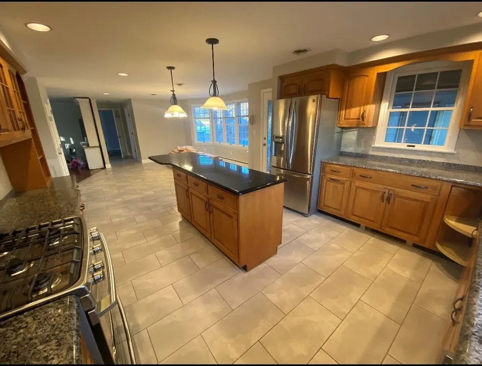 A kitchen with tile floors and stainless steel appliances.