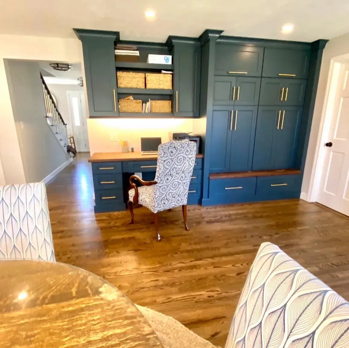 A room with blue cabinets and wooden floors.