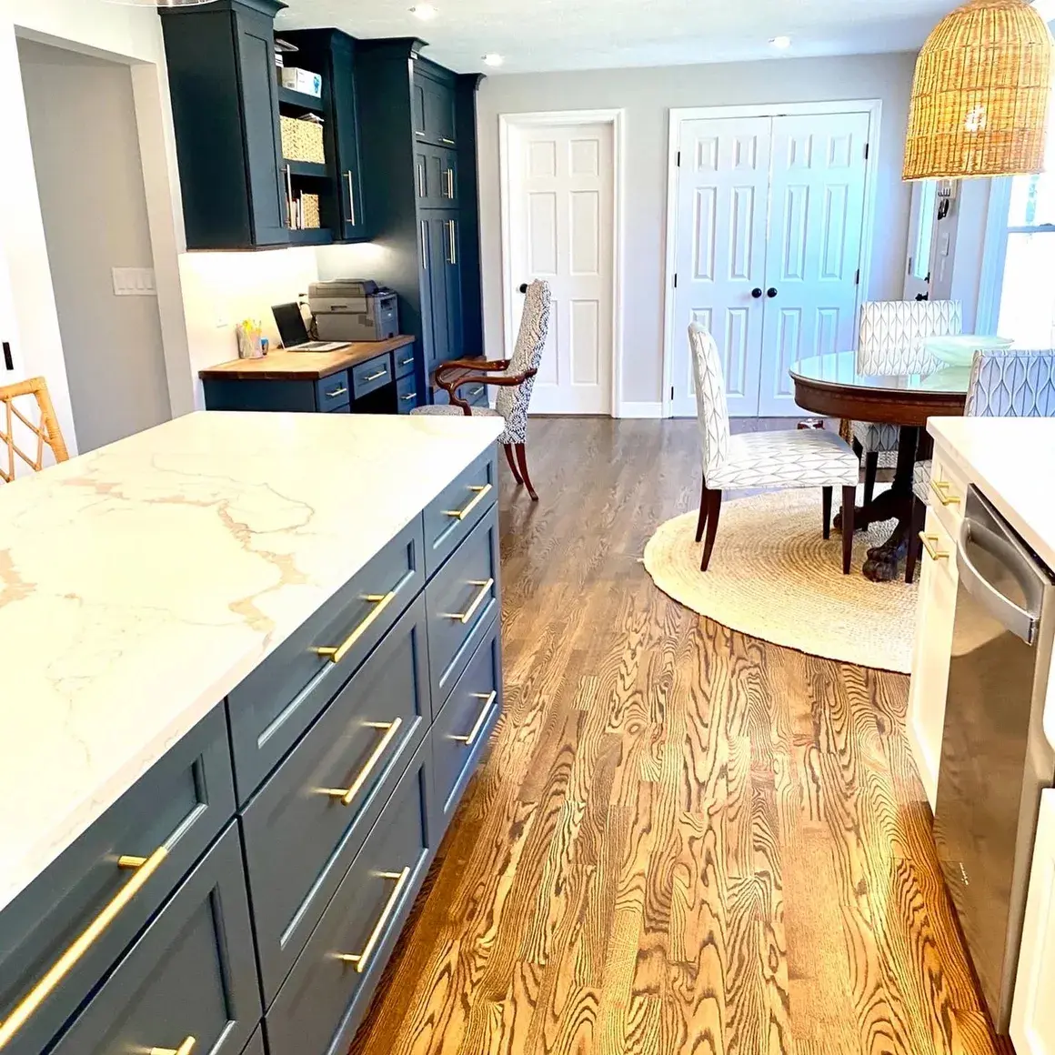 A kitchen with wood floors and white counters.