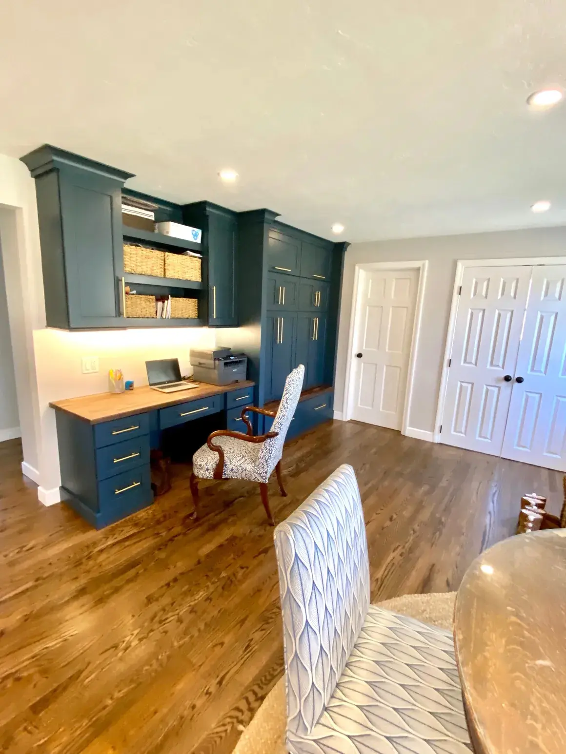 A room with a desk and chairs in it