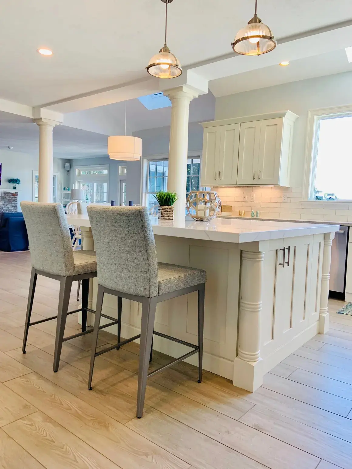 A kitchen with white cabinets and a large island.