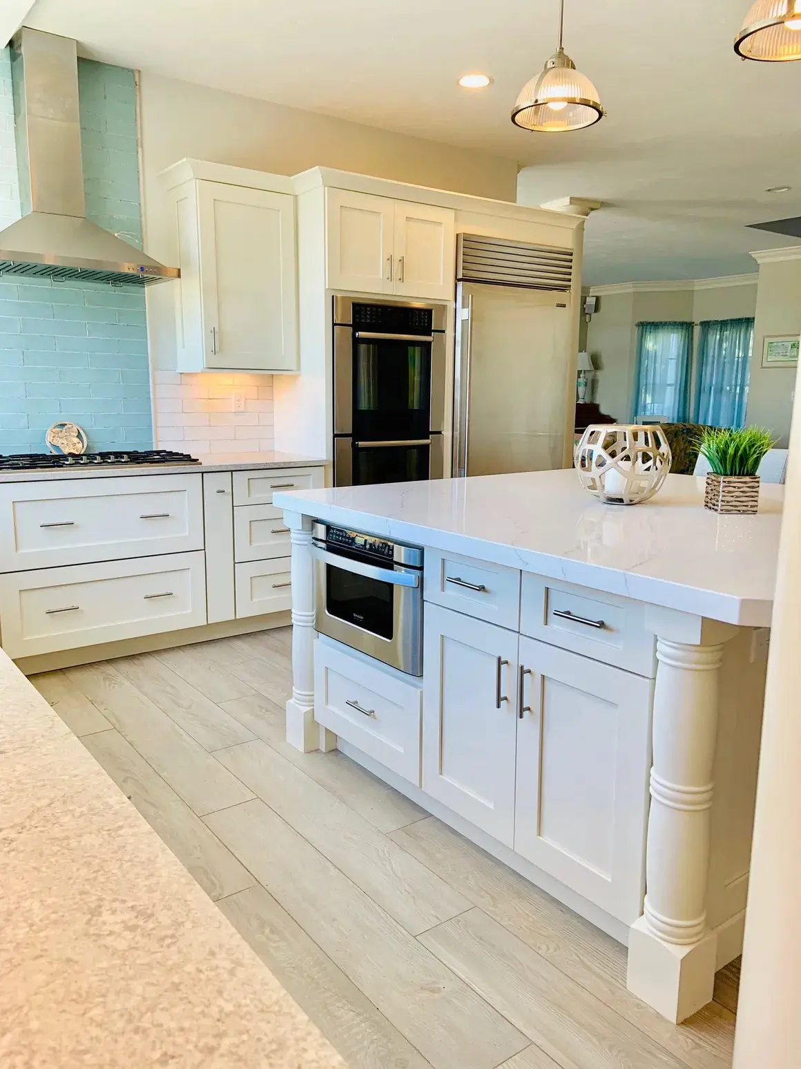 A kitchen with white cabinets and island in it