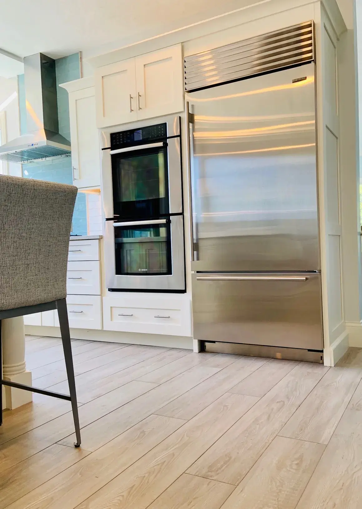 A kitchen with stainless steel appliances and white cabinets.