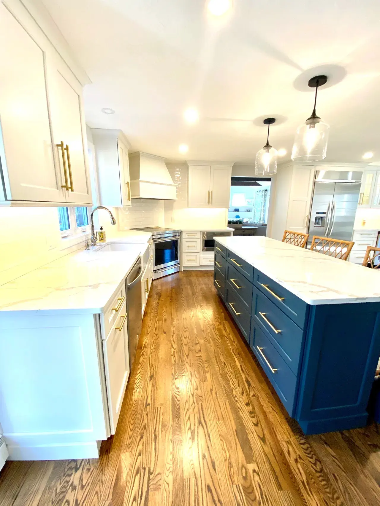 A kitchen with white cabinets and blue island.