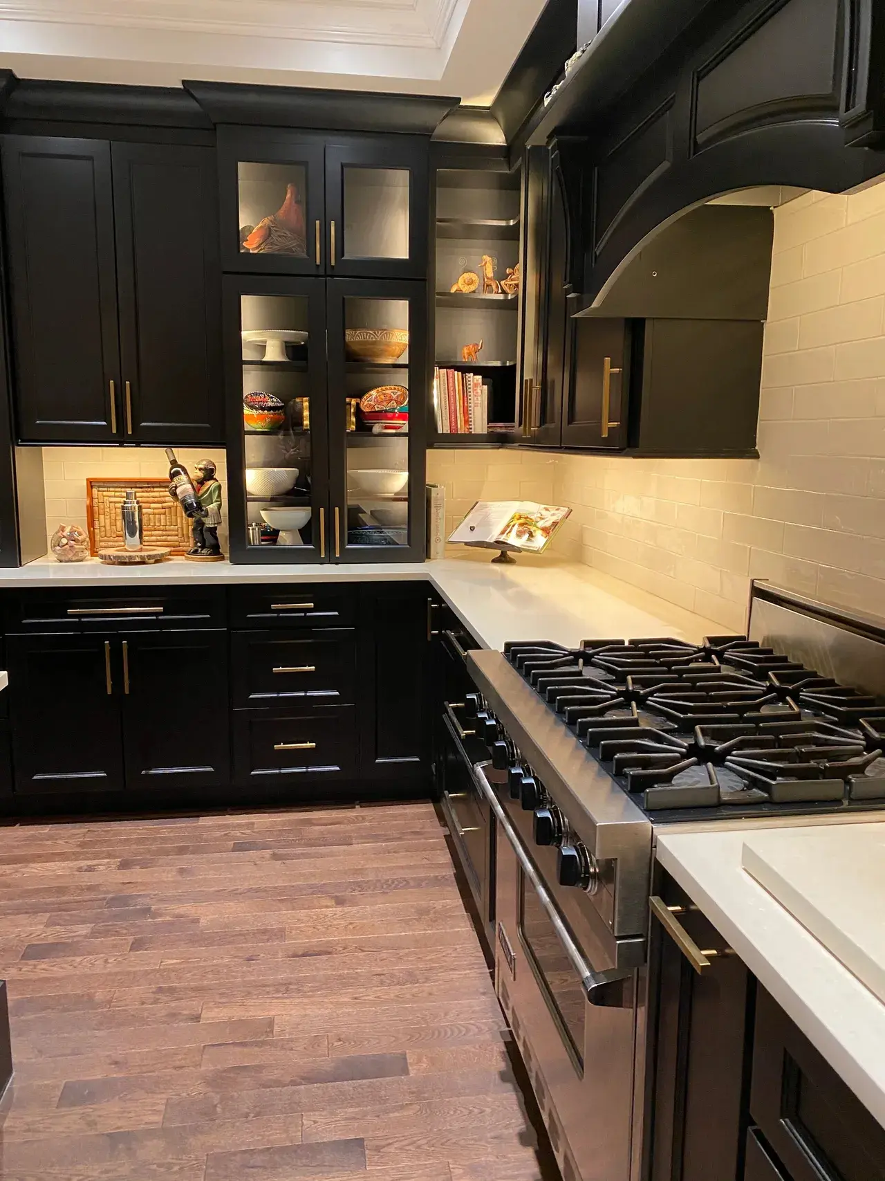 A kitchen with black cabinets and white counters.