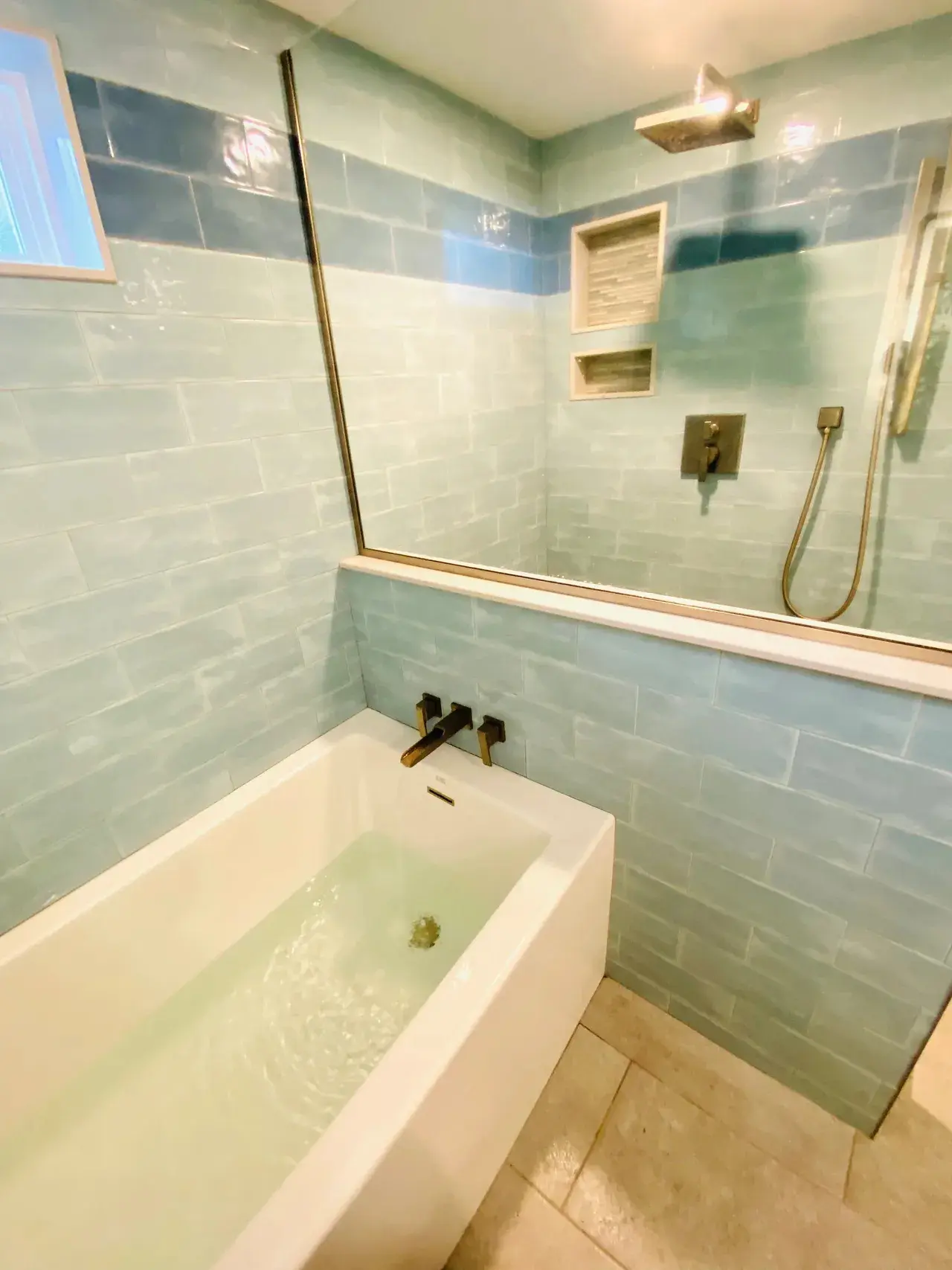 A bathroom with a tub, shower and mirror.