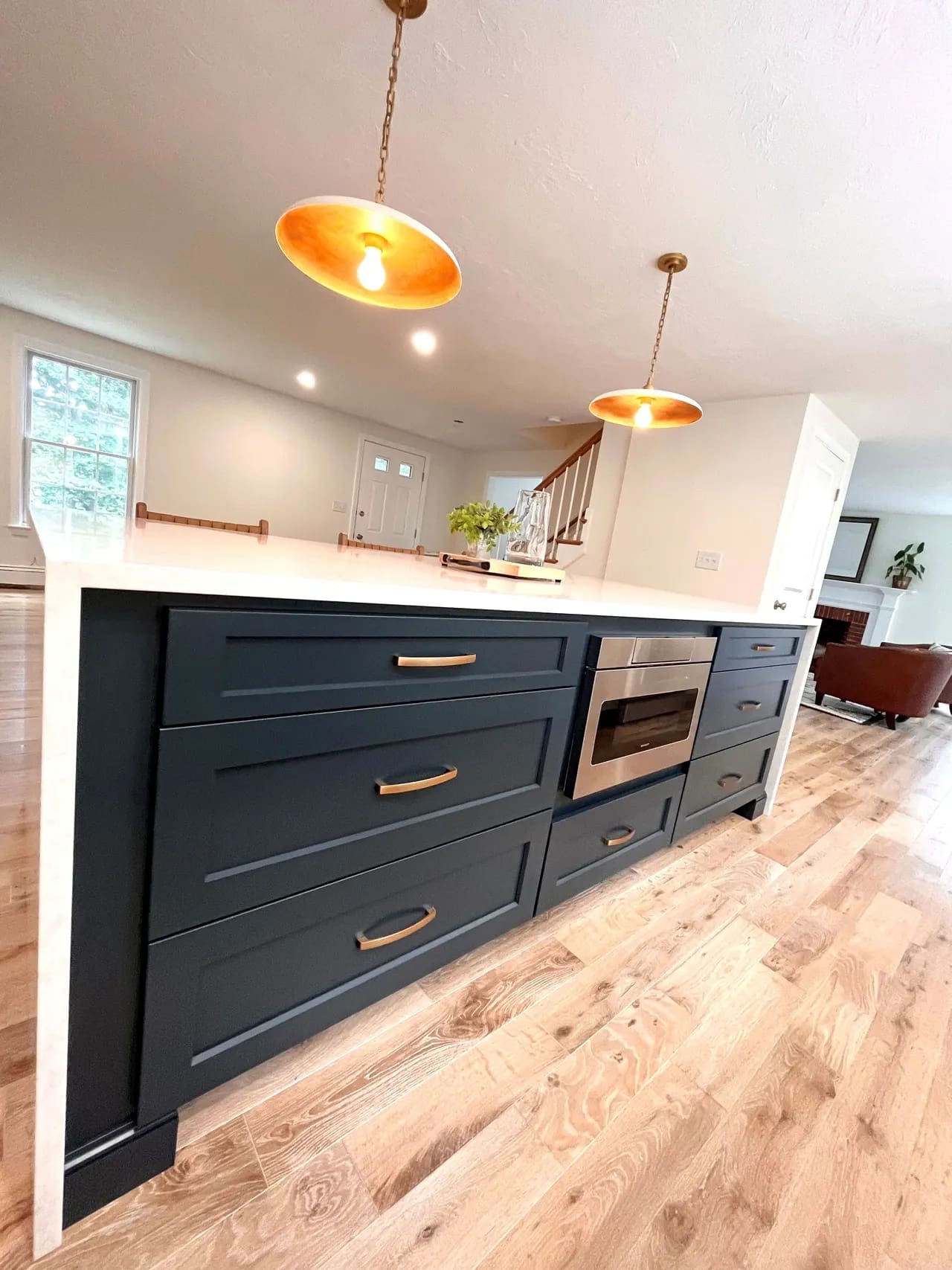 A kitchen with an island and gold lights