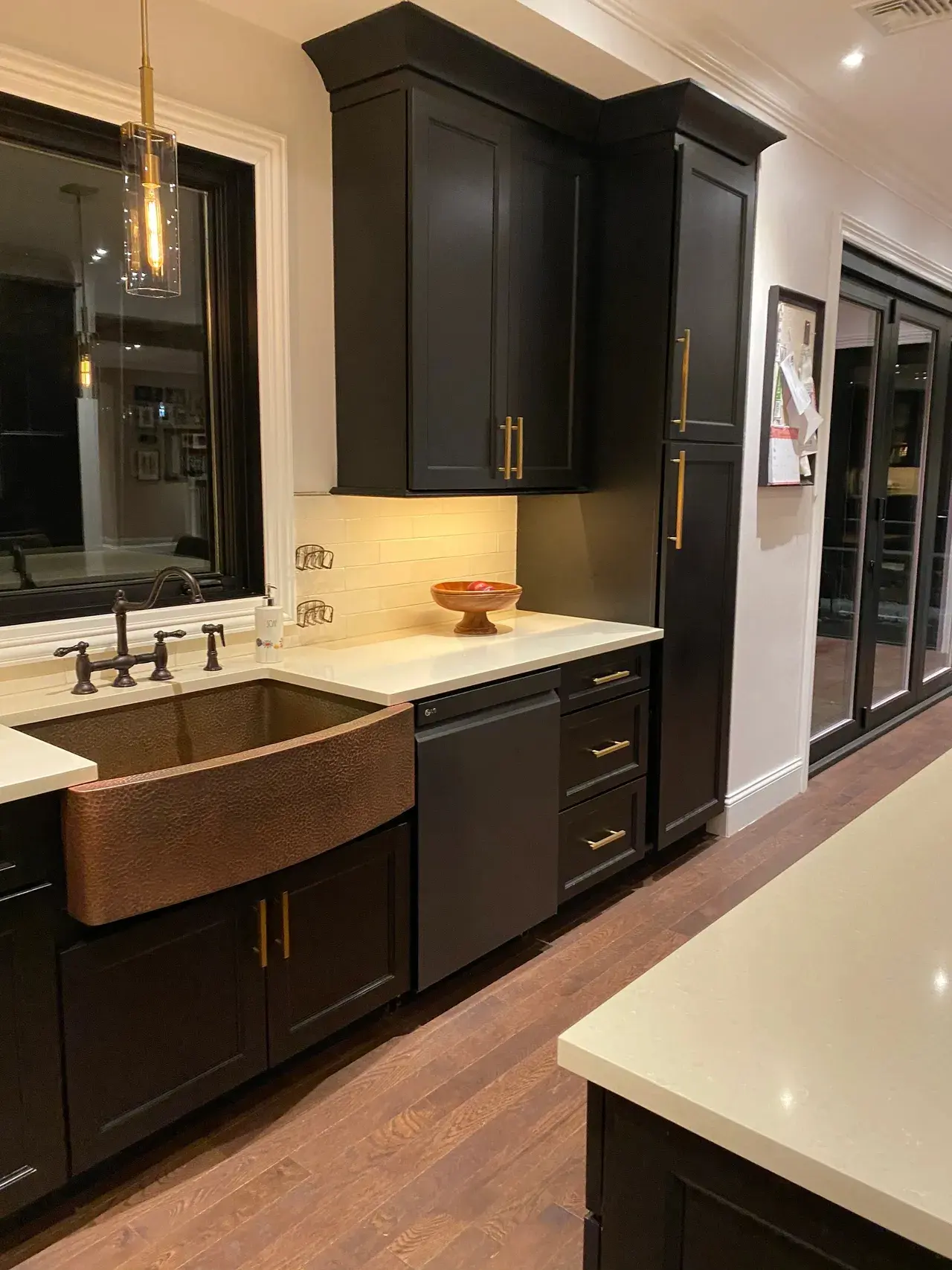 A kitchen with black cabinets and white counter tops.