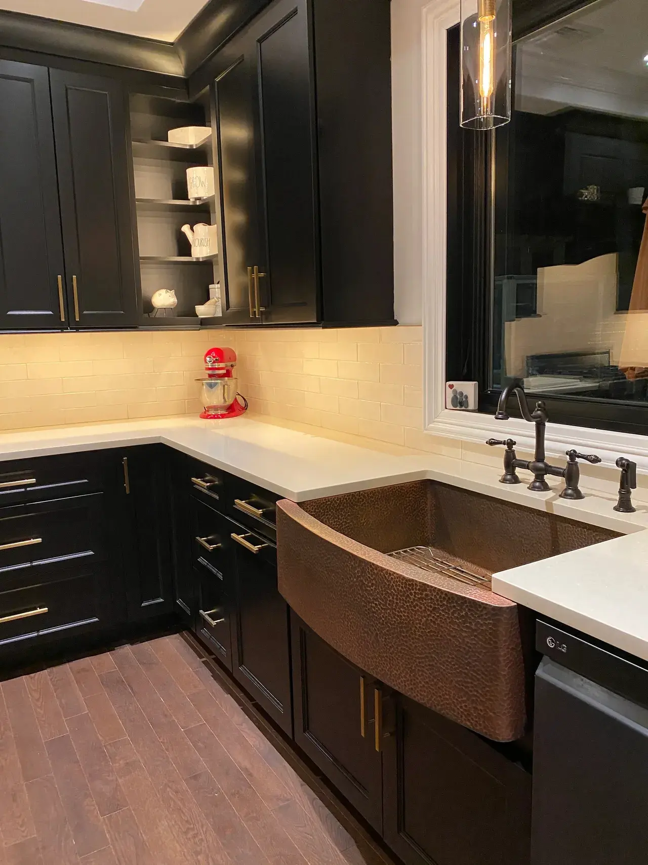 A kitchen with black cabinets and white counter tops.