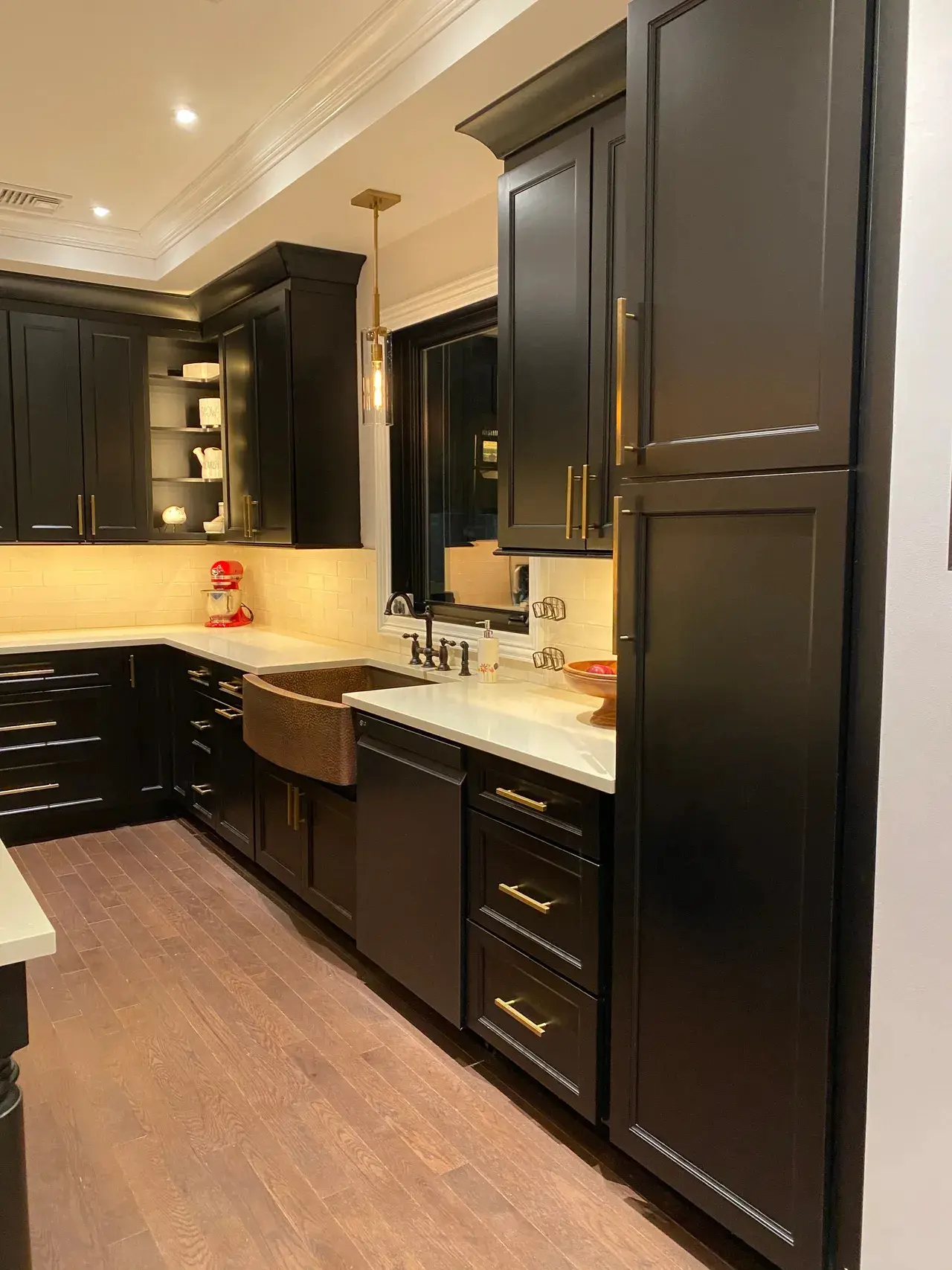 A kitchen with black cabinets and white counter tops.