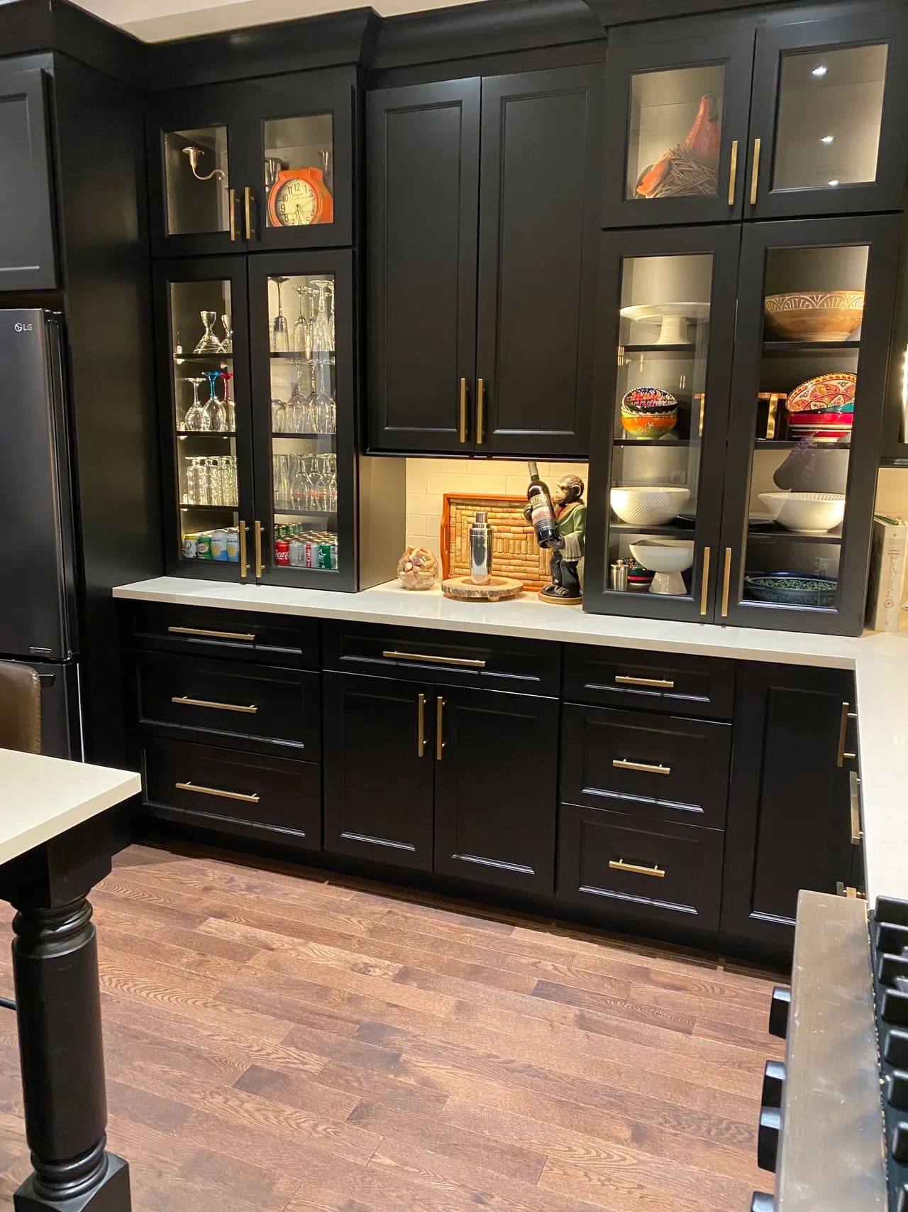 A kitchen with black cabinets and white counter tops.