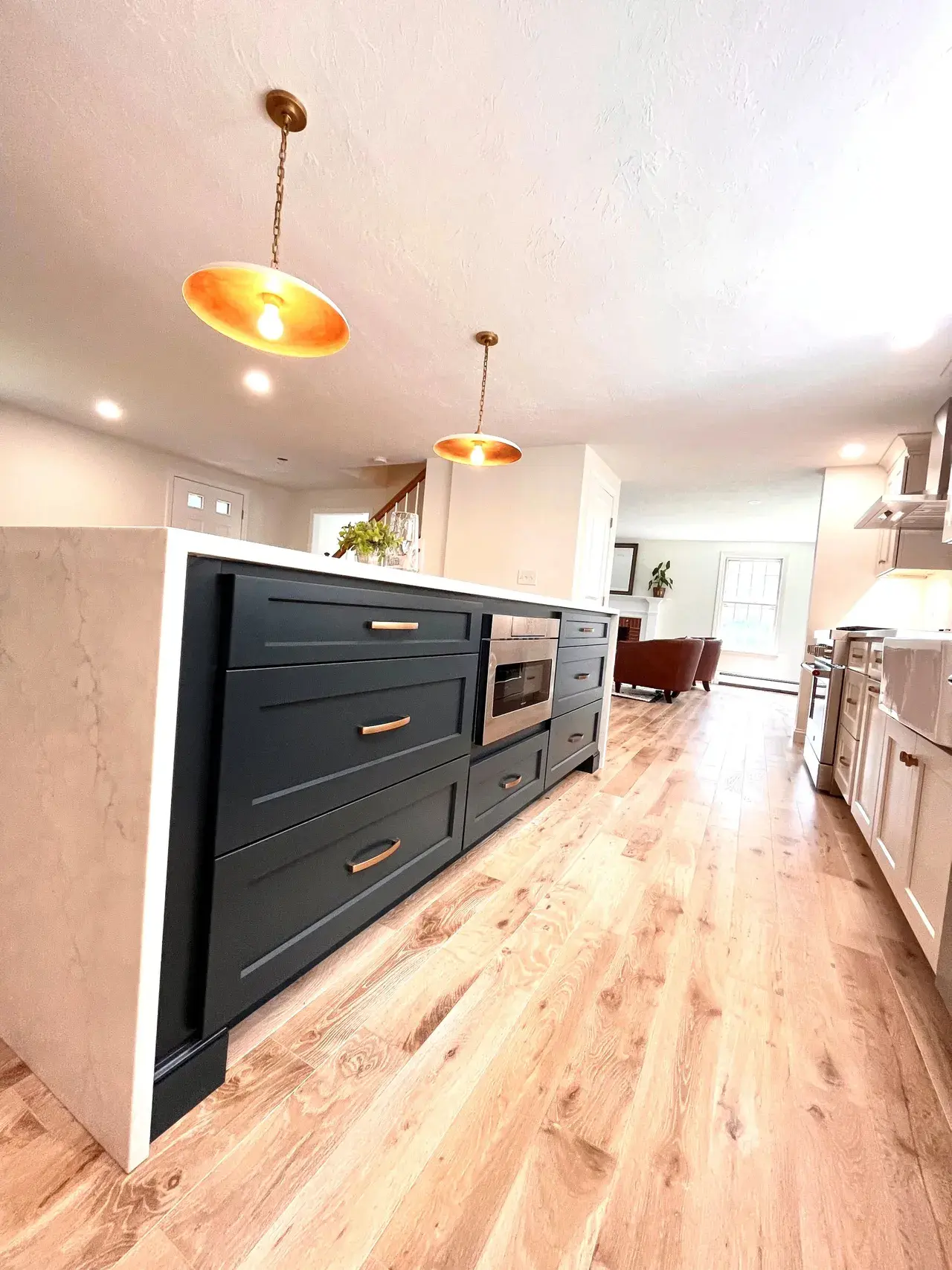 A kitchen with wood floors and blue cabinets.