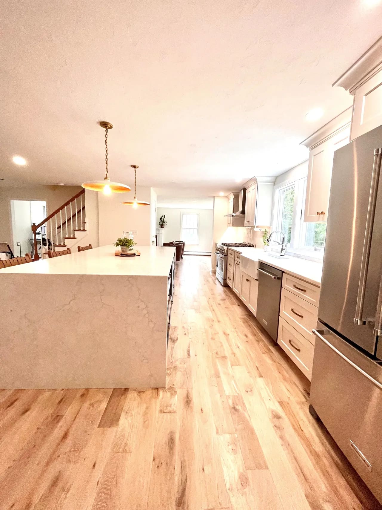 A kitchen with wood floors and white cabinets.