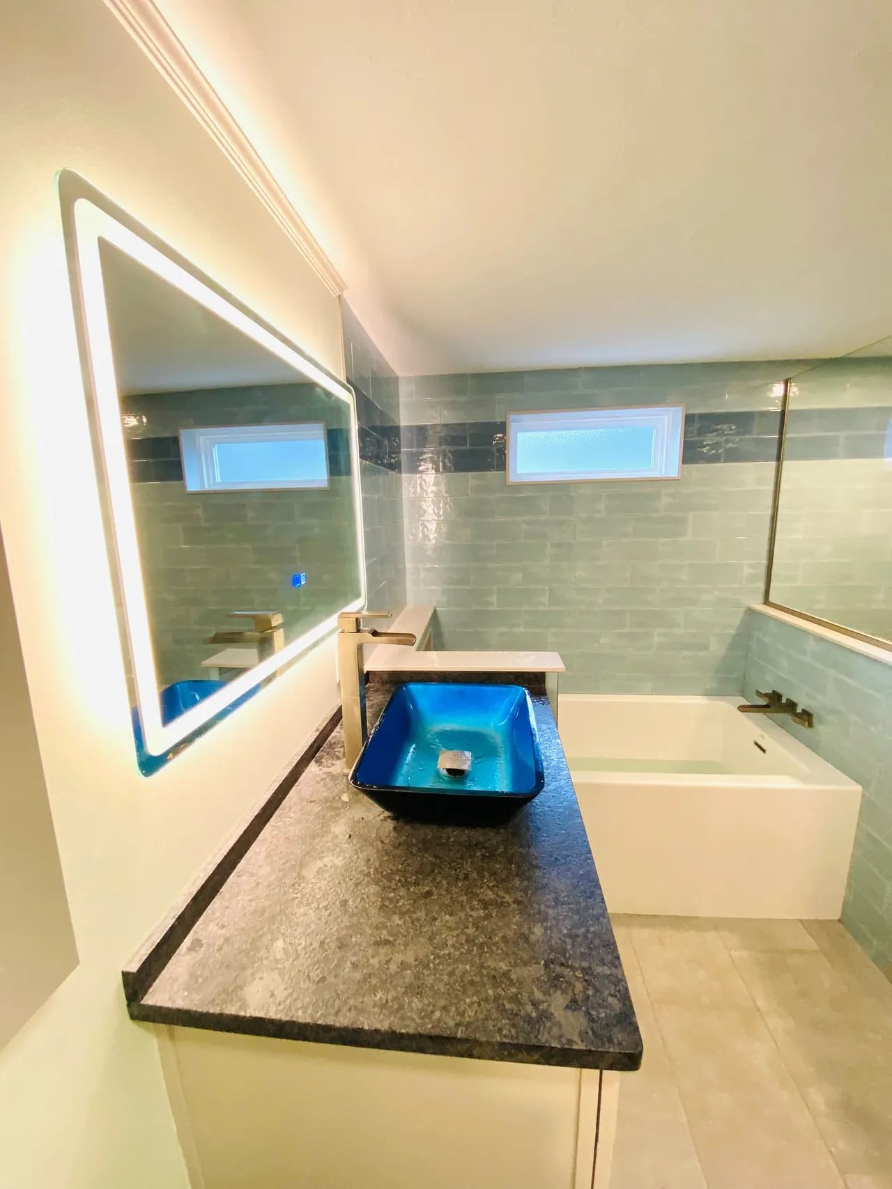 A bathroom with a sink, mirror and tub.