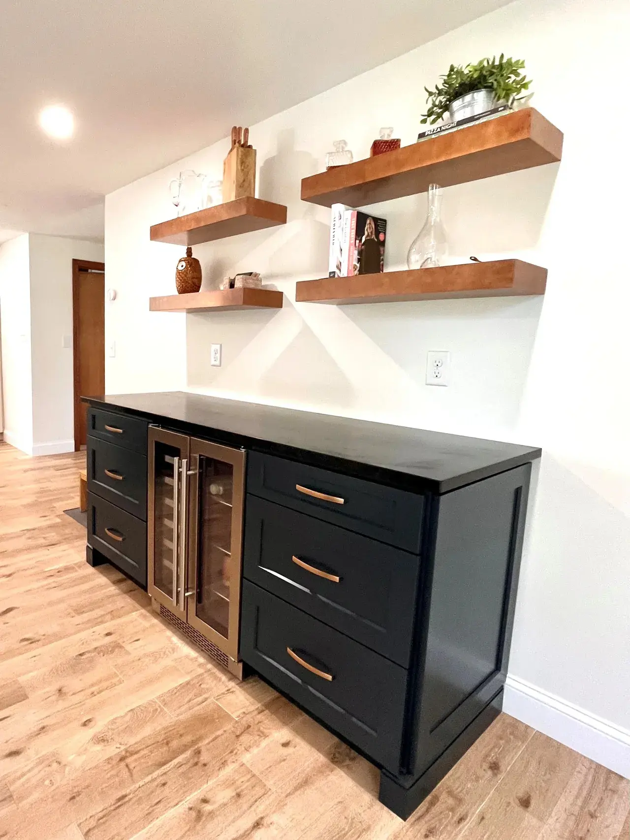 A black cabinet with drawers and shelves above it.