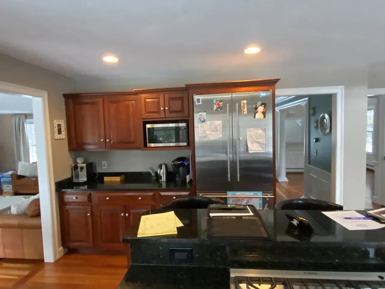 A kitchen with wood cabinets and black counter tops.