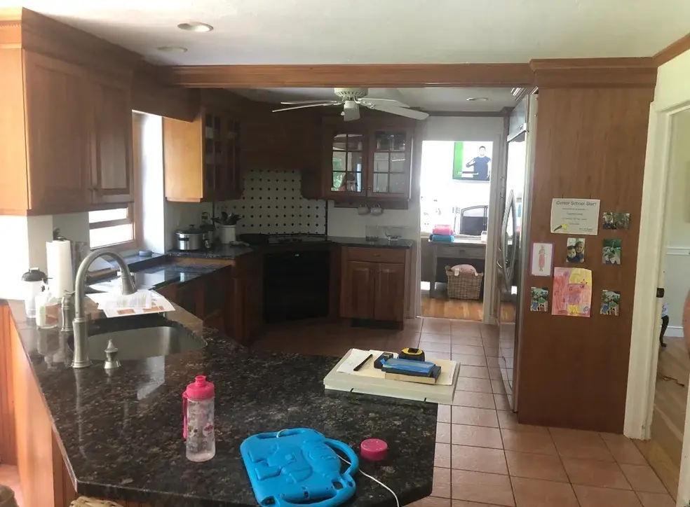 A kitchen with brown cabinets and tile floors.