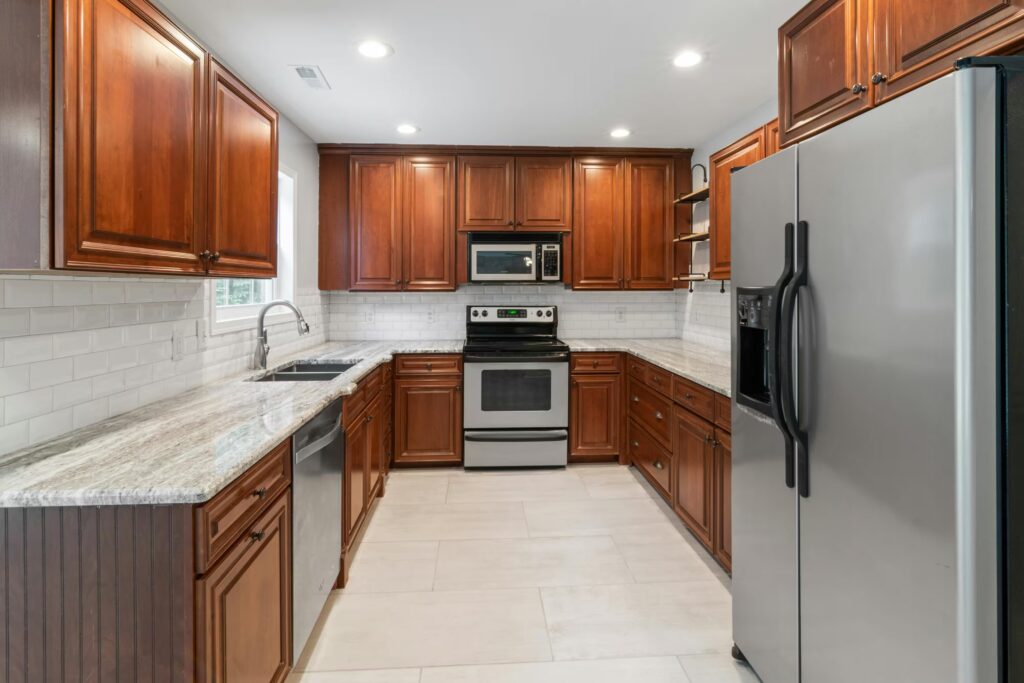 Kitchen design in Marshfield, MA featuring traditional wood cabinetry, granite countertops, and stainless steel appliances.