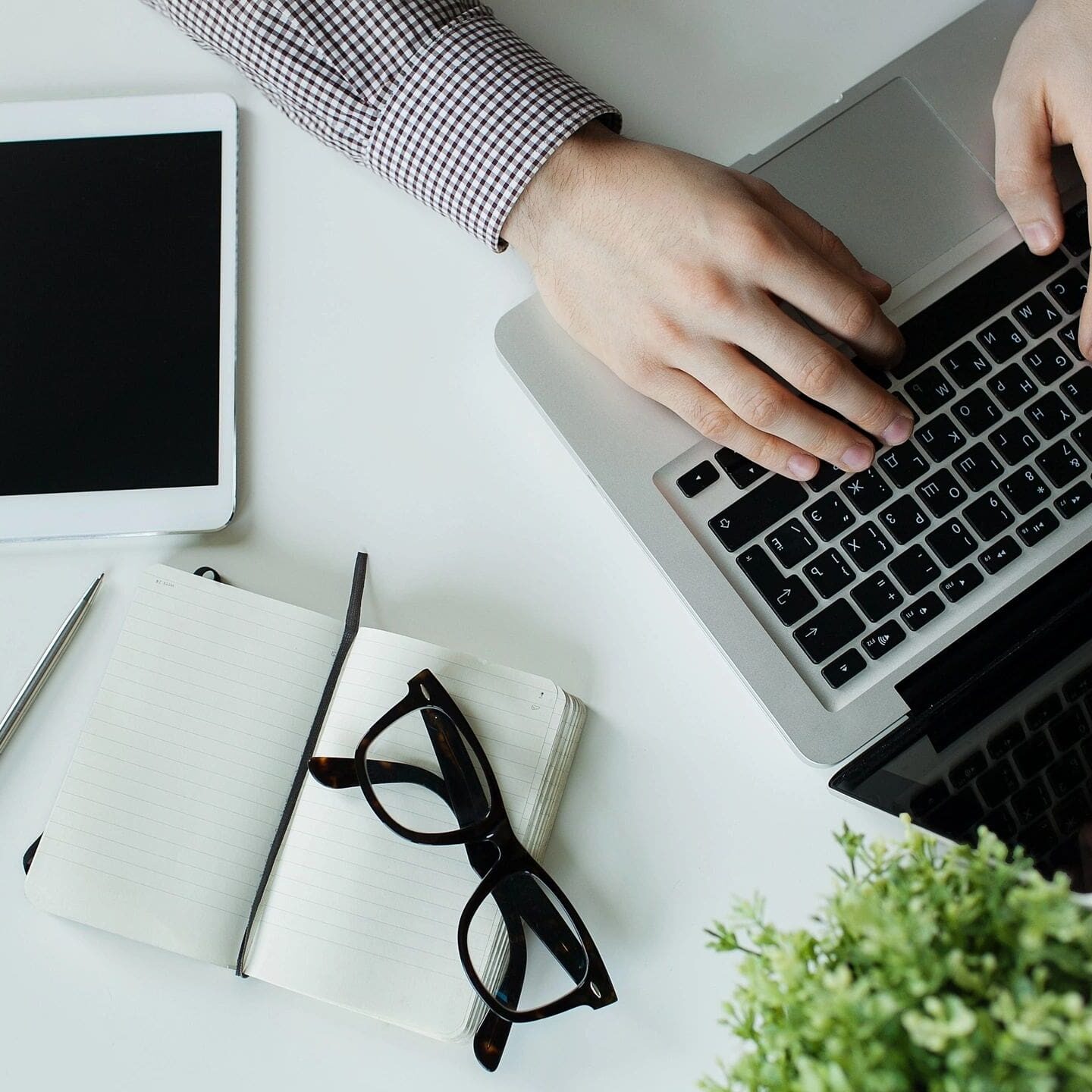 A person using their laptop on the desk