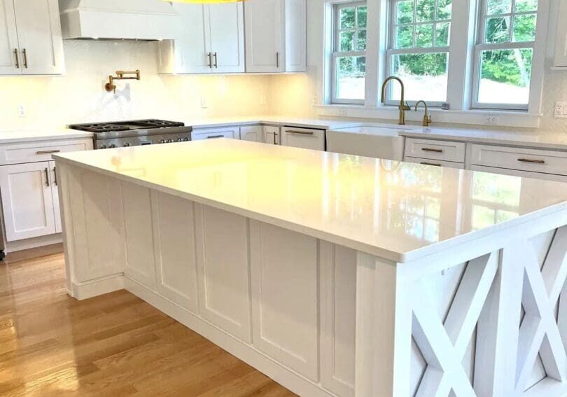 A kitchen with white cabinets and black lights